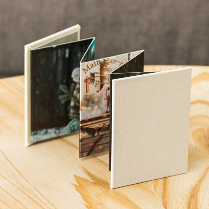 Accordion mini brag book with a white art cloth cover.