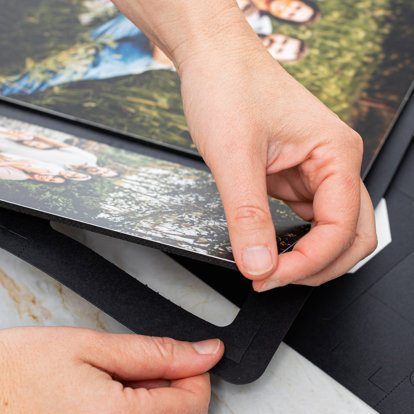 Someone placing the backing on a metal photo tile. 