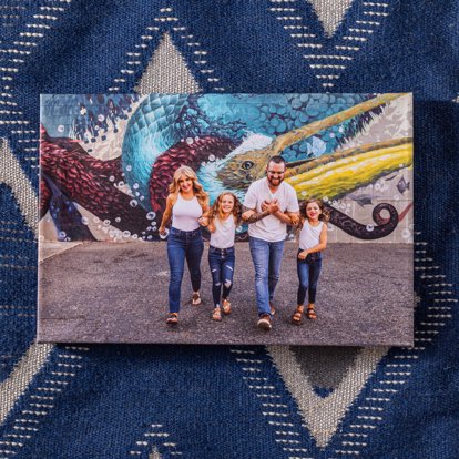 a colorful canvas print wrap featuring a family posing in a parking lot with a wall of graffiti behind them