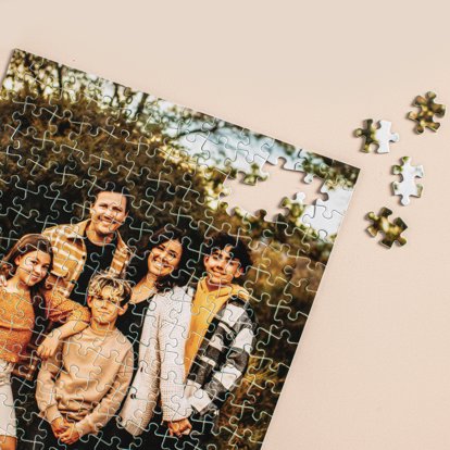 A close up of the top and corner of a photo puzzle featuring a posed image of a family in a field.