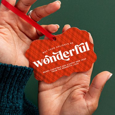 A hand holding a metal ornament from Mpix showing the glossy finish.