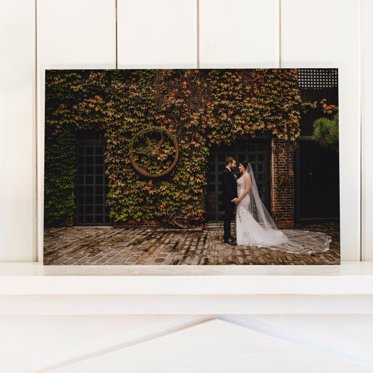 An Acrylic Photo Print from Mpix of a couple dancing in front of a large earthen textured wall on their wedding day. 