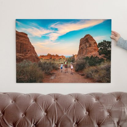 A colorful metal print of a father and two kids walking on a trail through the Grand Canyon. 