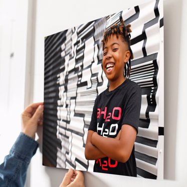 Metal photo print from Mpix being float mounted to a wall featuring a young man posing in front of a wall of graffiti. 