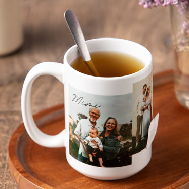 White photo mug filled with tea, featuring family photos, displayed on a wooden tray with warm, cozy holiday ambiance.