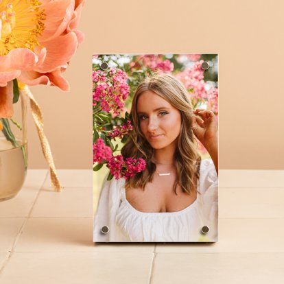 A vertical birch photo block from Mpix featuring a print from a high school senior photo session that is displayed on a table.