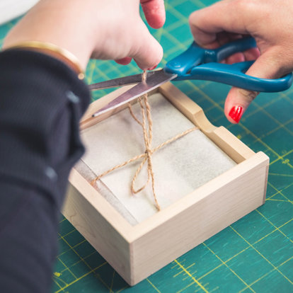 a worker prepares the packaging for the prints in the wood photo box