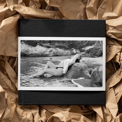 A Premium Hardcover Photo Book with a Black Linen Cover and Skinny Dust Jacket featuring a boudoir photo