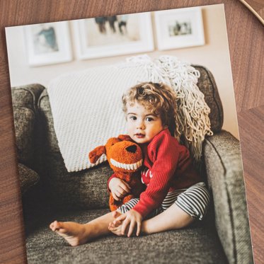 Giclee Photo Print from Mpix featuring a portrait of a toddler with his stuffed animal on a comfy couch. 