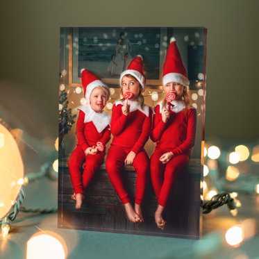 Acrylic Photo Block from Mpix featuring three young girls in matching santa elf costumes posing for christmas photos. 