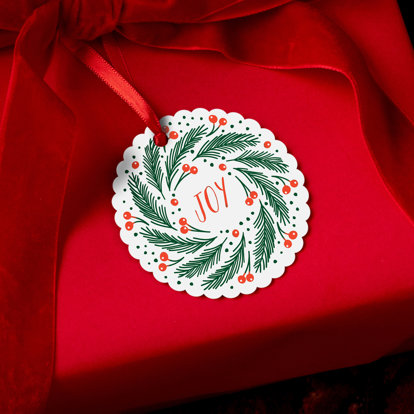 A circular photo ornament with a wreath of holly and the word 'Joy' in the middle. 