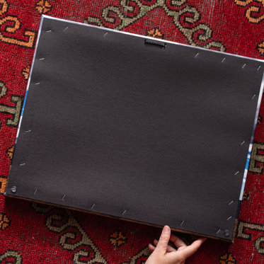 the back of a canvas print that shows its protective layer and the sawtooth hanger accompanying the print