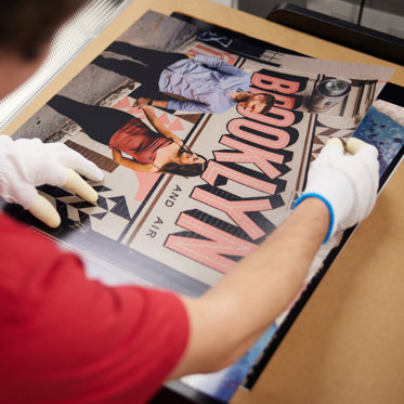 a worker in the mpix lab preparing to mount a professional quality photo print on foam