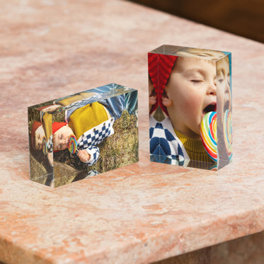 Two 2x3" mini acrylic blocks. One displayed horizontally and the other vertically. Both blocks feature photos of a toddler boy licking a giant colorful lollipop.