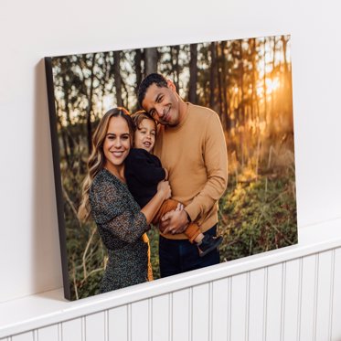 Standout Photo Print from Mpix leaning against the wall featuring a family posing for their family portraits in the woods at sunset.