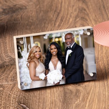 A birch photo block displayed on a table featuring a photo of a bride with her mom and dad.