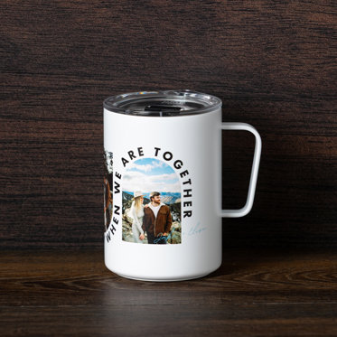 A travel mug camp cup on a table and personalized with a photo of a couple and the text "Jake + Elise"