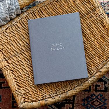 A Hardcover Photo Book with a Graphite Gray Linen cover and foil stamped debossed text that reads "XOXO My Love"