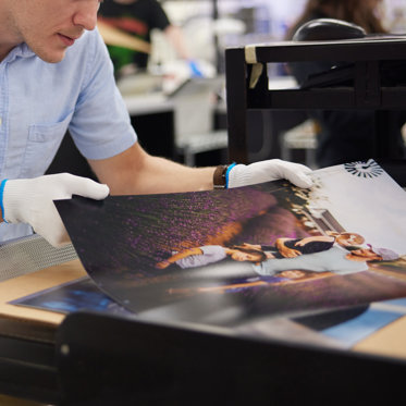 A worker inspects photo prints in our lab for quality and color accuracy. Every photo is hand reviewed. 