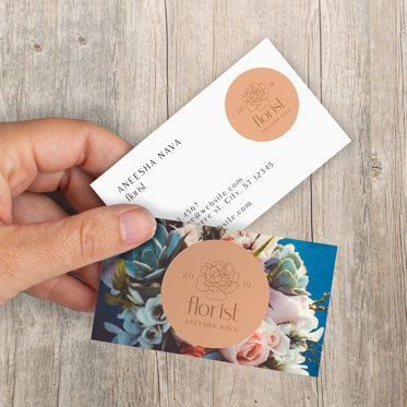 A colorful business card featuring flowers for a florist with their logo in the middle, the back offers more business details.