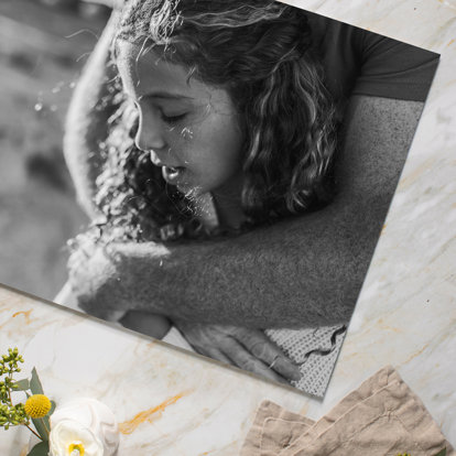 A Black & White Print with a photo of a girl being hugged by her mother..