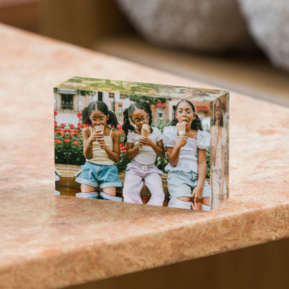 A 2x3 mini acrylic photo block displayed horizontally featuring a photo of three young sisters sitting on a bench eating ice cream cones.