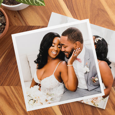 Two softcover photo books stacked on a table featuring wedding photos.