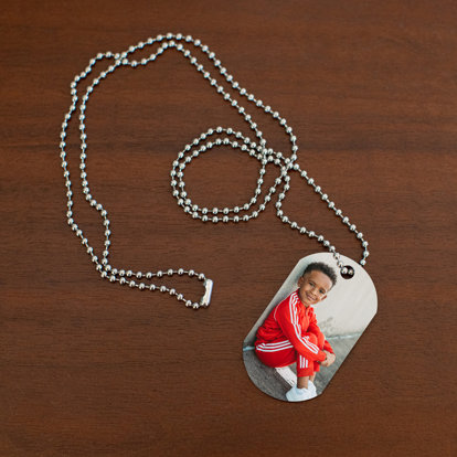 Photo dog tag necklace resting on table with a photo of a young man.