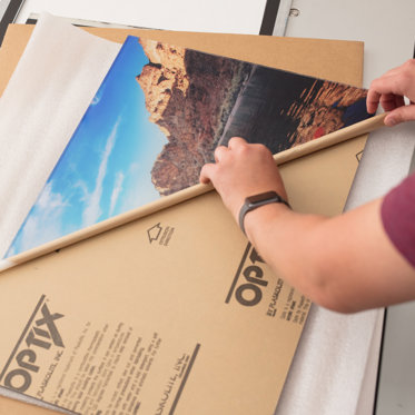 A worker in our lab unwraps an acrylic print after the UV transfer process.