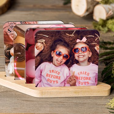 Mpix personalized coaster set in wooden stand with photo of two sisters wearing sunglasses.