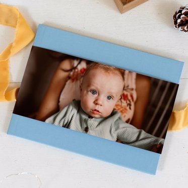 A blue art cloth classic photo book with a skinny dust jacket for an added personalized touch.
