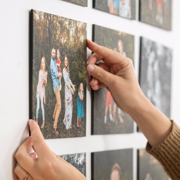 Photo tiles arranged on a wall in a grid, ready to be cleaned with a microfiber cloth to help remove dust or fingerprints. 
