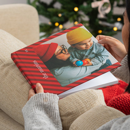 A premium photo book with a custom image cover featuring a plaid design and holiday-themed image of a mother and son.