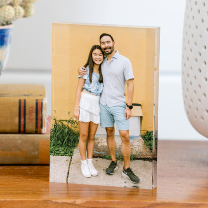 An acrylic photo block standing on a table and featuring a picture of a father and daughter.