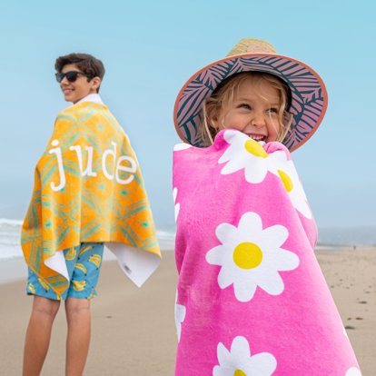 Kids on the beach wrapped up in their personalized towels.