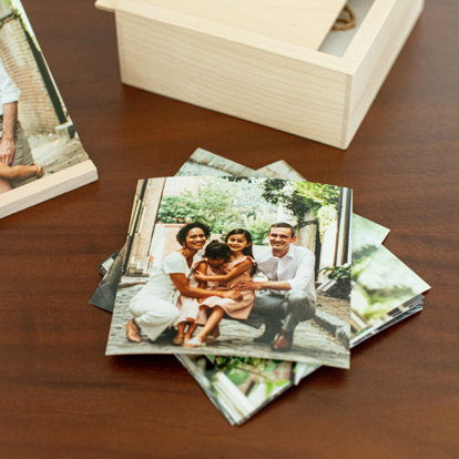 loose prints on a table next to the wood photo box