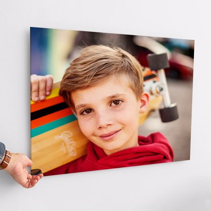 Acrylic Photo Print mounted on a wall featuring a young kid holding a skateboard.