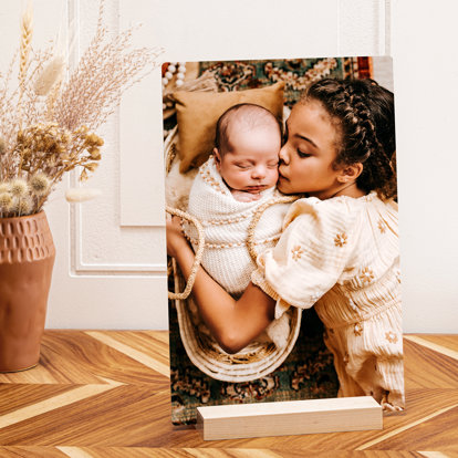 a tall tabletop metal print showing off a family photo of a mother and a newborn