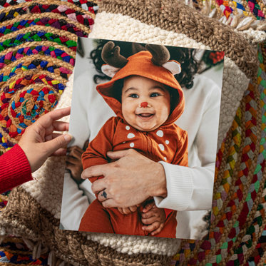 Personalized photo print from Mpix of a smiling child in a reindeer outfit.
