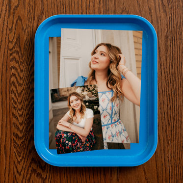 Several premium quality photo prints from Mpix sitting in a tray featuring senior photos of an upcoming graduate. 