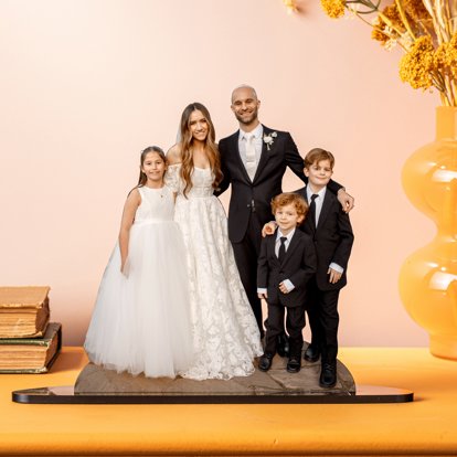 A die cut Statuette of a cut out wedding photo of a bride, groom, and children.