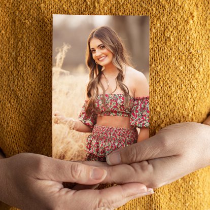 Personalized photo print from Mpix being held featuring a photo of a young girl posing in a field.