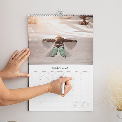 Someone marking a special date on their customizable wall calendar.