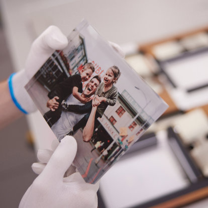 A worker holding an acrylic block print and making sure the image is perfect