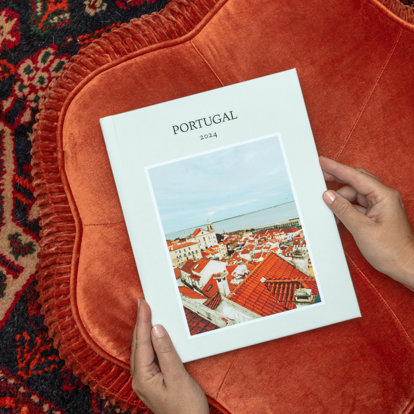 A premium photo book with a travel theme featuring a scenic photo and the text "Portugal 2024"