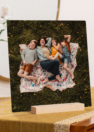 a square tabletop metal print showing a family having a picnic