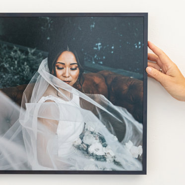 a gorgeous framed print of a bride with a thin metal frame being cared for 