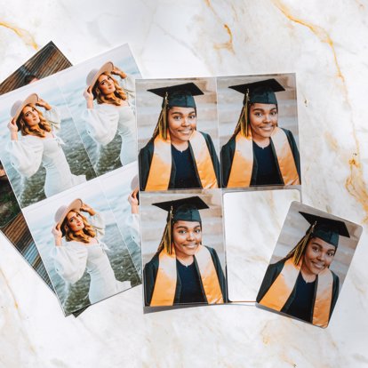 A collection of senior wallet photo prints from Mpix with rounded and straight corners featuring senior photos, all sitting on a countertop. 