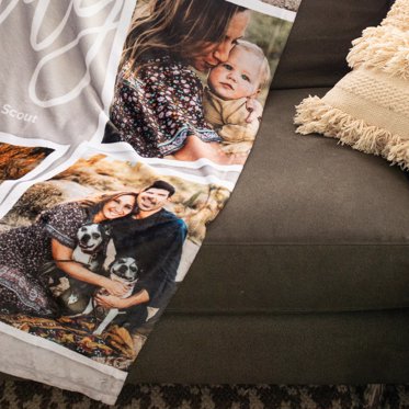 A personalized fleece photo blanket on a couch.