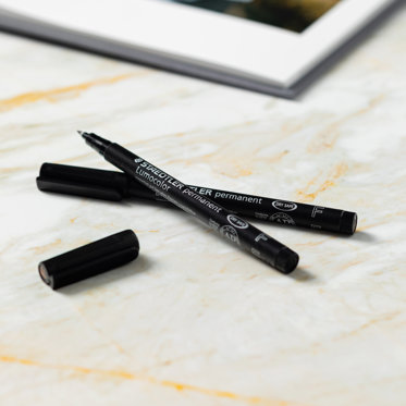 A close-up image of the pens that are included with each guest book.